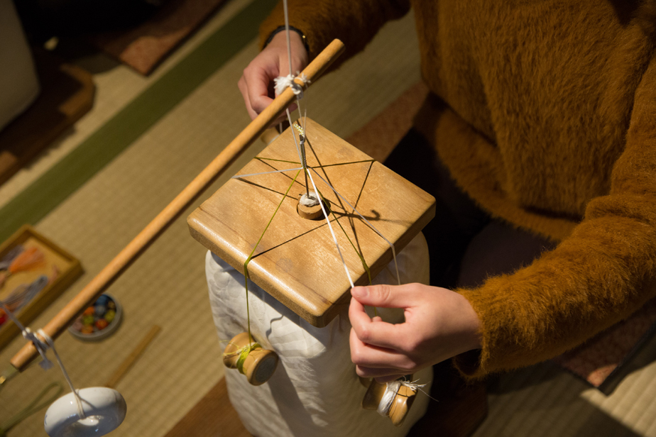 糸の束を持ち上げると思っていたより重たくてびっくり！重りは糸巻きの機能も兼ねています。